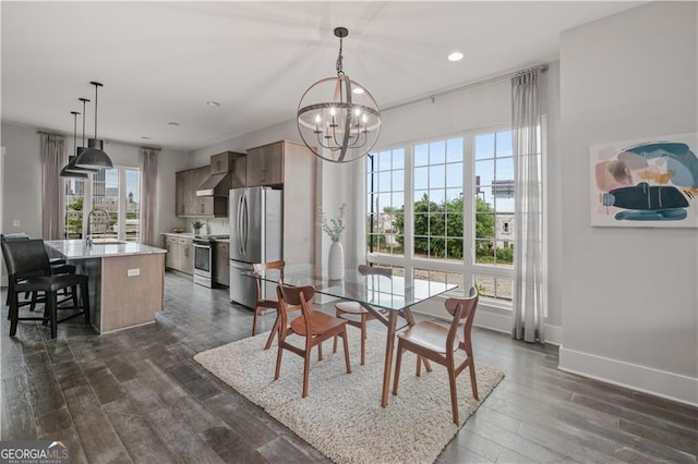 dining room with a notable chandelier, dark hardwood / wood-style floors, and sink