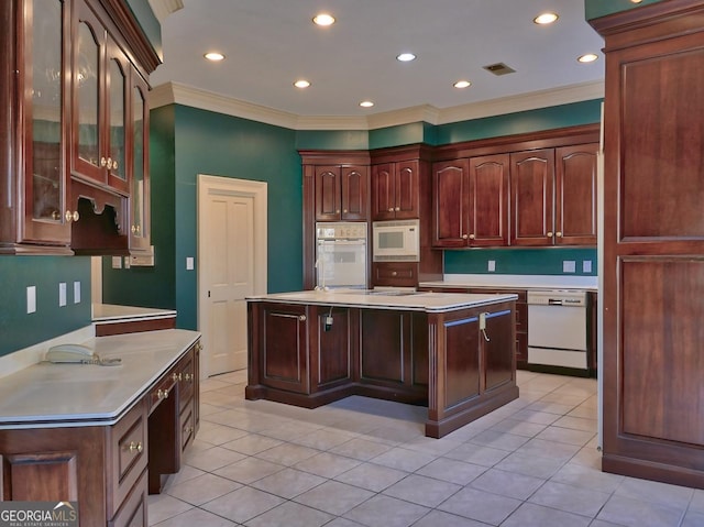 kitchen with light tile patterned flooring, white appliances, crown molding, and a kitchen island