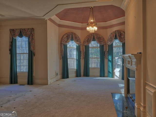 interior space with carpet floors, ornamental molding, and a notable chandelier