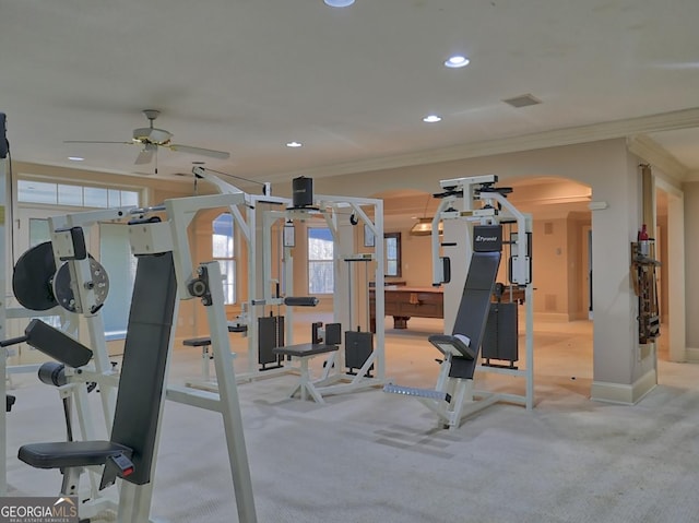 workout area with ceiling fan, light colored carpet, and crown molding