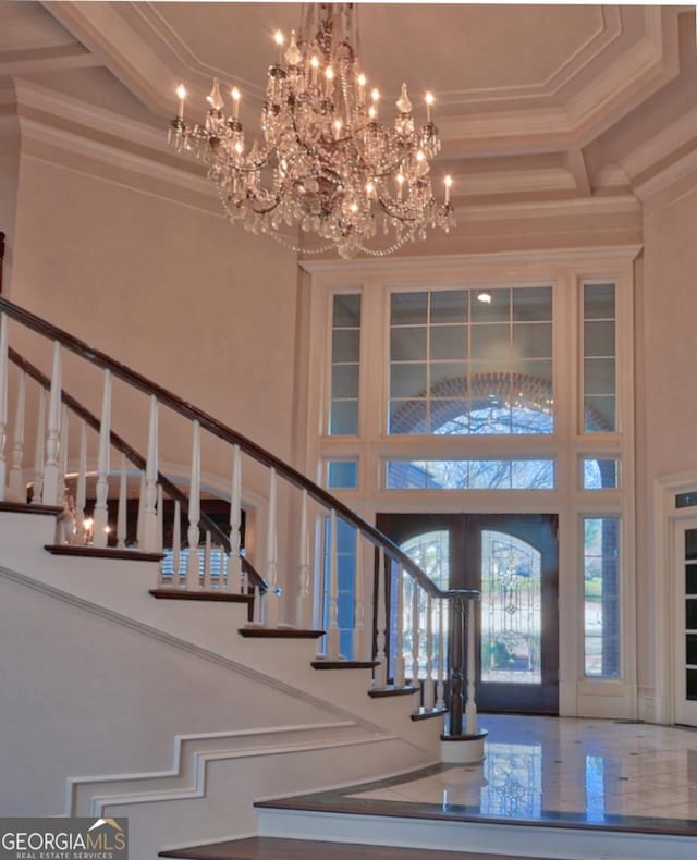 entrance foyer featuring a towering ceiling and ornamental molding