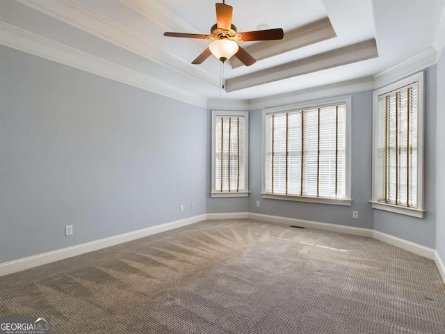 unfurnished room with ceiling fan, carpet, a tray ceiling, and crown molding