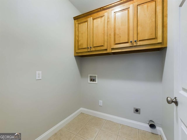 clothes washing area with washer hookup, cabinets, light tile patterned flooring, and hookup for an electric dryer