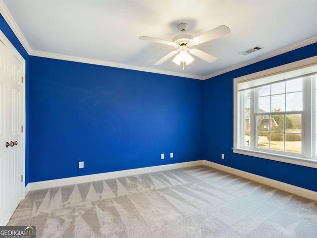 carpeted empty room with ceiling fan and ornamental molding