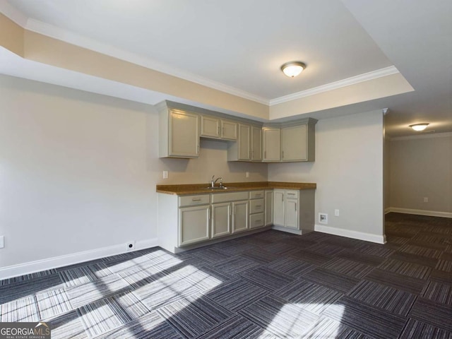 kitchen with gray cabinets, ornamental molding, dark carpet, and sink