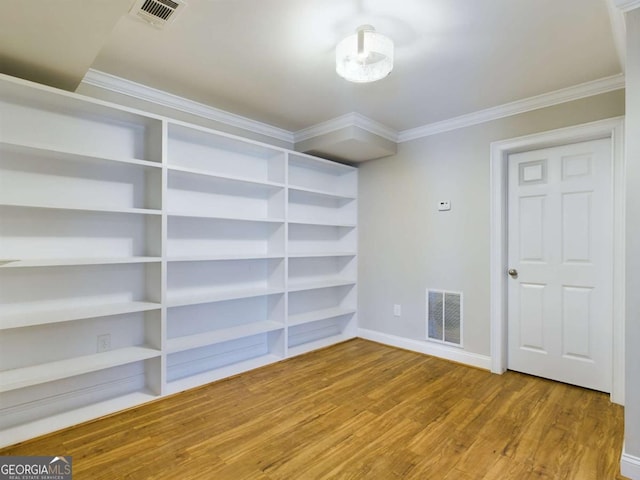 empty room featuring crown molding and hardwood / wood-style floors