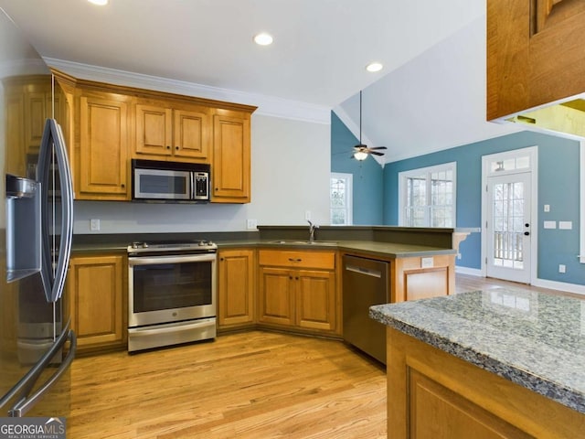 kitchen featuring ceiling fan, kitchen peninsula, sink, light wood-type flooring, and stainless steel appliances