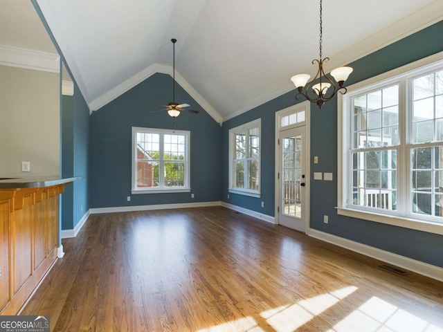 unfurnished dining area with ceiling fan with notable chandelier, wood-type flooring, crown molding, and vaulted ceiling