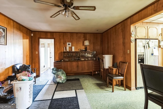 interior space with light carpet, ceiling fan, and wood walls