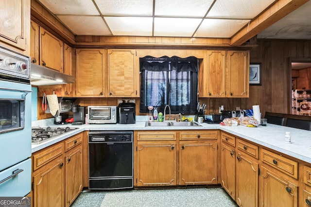 kitchen featuring stainless steel gas stovetop, wooden walls, black dishwasher, a paneled ceiling, and sink