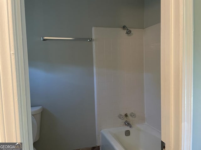 bathroom featuring tiled shower / bath combo and toilet