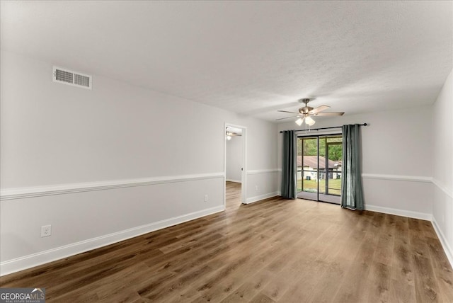 spare room featuring ceiling fan, wood-type flooring, and a textured ceiling