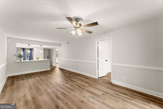 unfurnished living room with ceiling fan and hardwood / wood-style floors