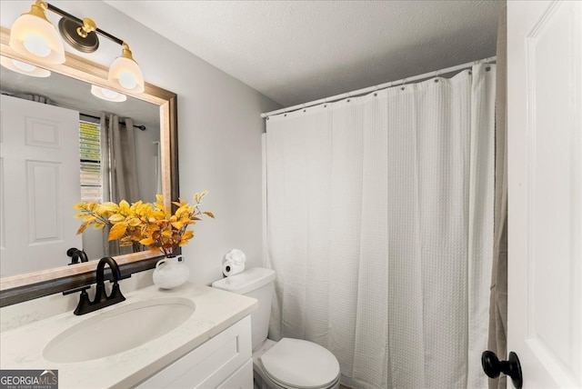 bathroom with toilet, vanity, and a textured ceiling