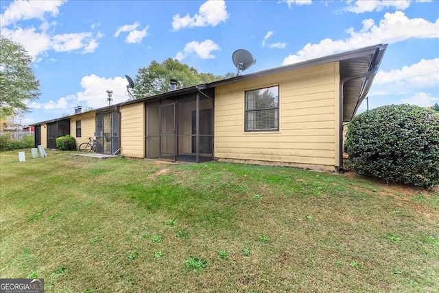 back of house featuring a sunroom and a yard