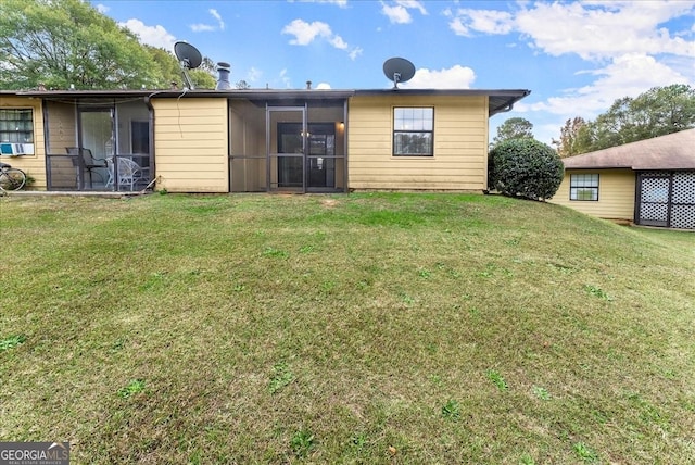 back of property with a sunroom and a yard