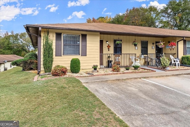 ranch-style house with a front yard and covered porch