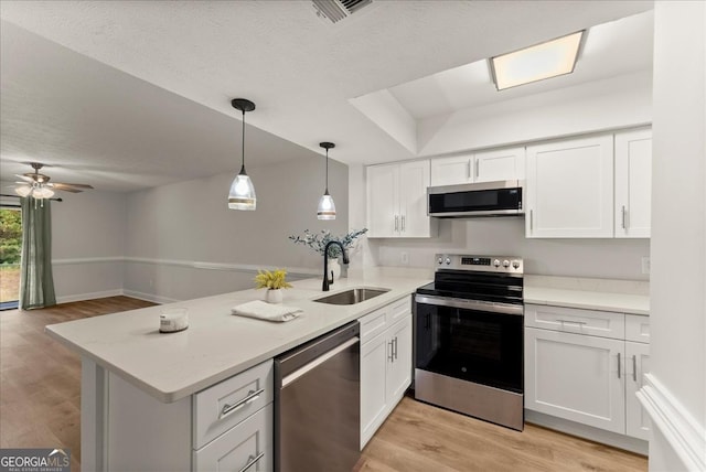 kitchen featuring kitchen peninsula, ceiling fan, appliances with stainless steel finishes, white cabinets, and sink