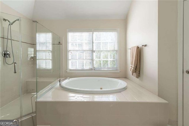 bathroom featuring vaulted ceiling and separate shower and tub