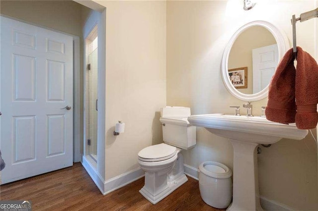 bathroom with hardwood / wood-style floors, toilet, and walk in shower