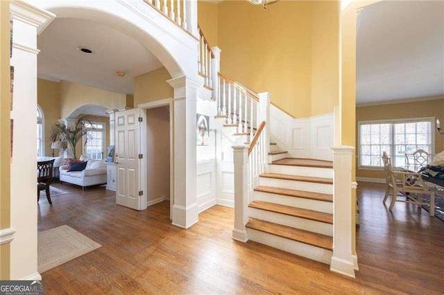 stairway with wood-type flooring and decorative columns