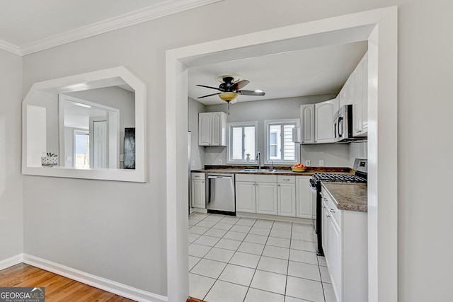 kitchen featuring white cabinetry, stainless steel appliances, sink, ceiling fan, and crown molding