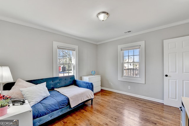 sitting room featuring hardwood / wood-style flooring, a wealth of natural light, and crown molding