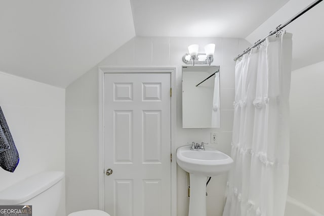 bathroom with toilet, shower / tub combo, and vaulted ceiling