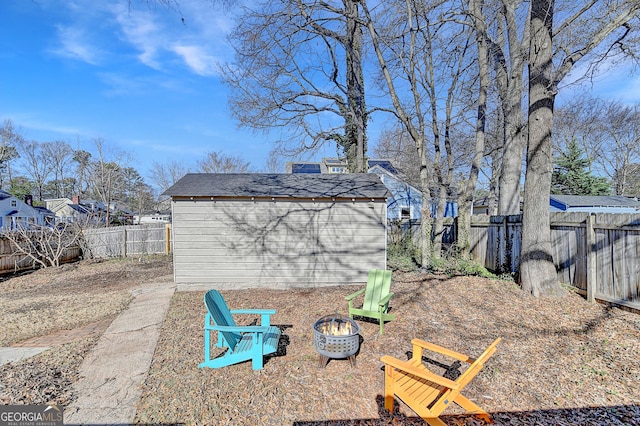 view of yard featuring a storage unit and a fire pit