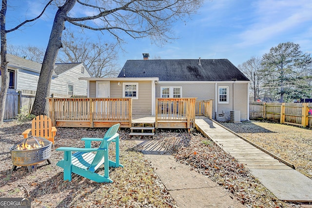 back of property featuring a fire pit, central AC unit, and a deck