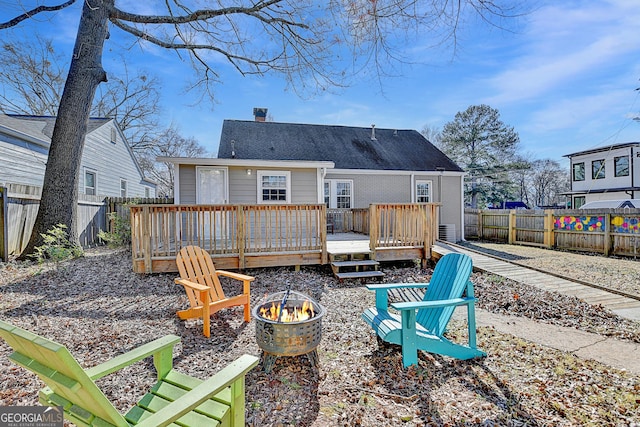 rear view of house featuring a deck and an outdoor fire pit