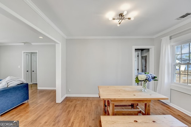 dining room featuring light wood-type flooring and ornamental molding