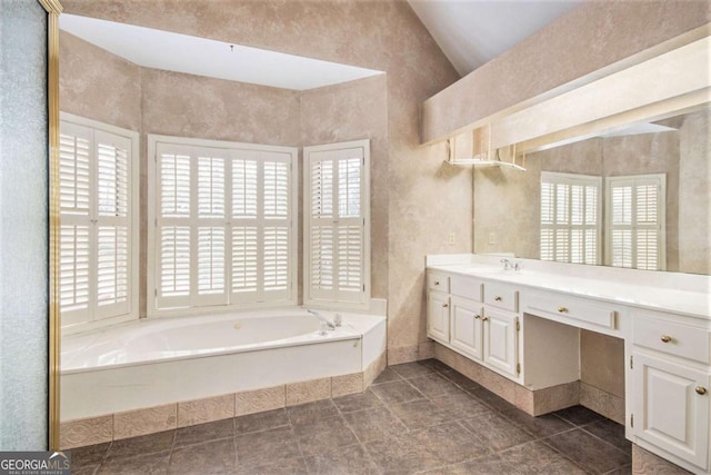 bathroom with vanity, vaulted ceiling, and plenty of natural light