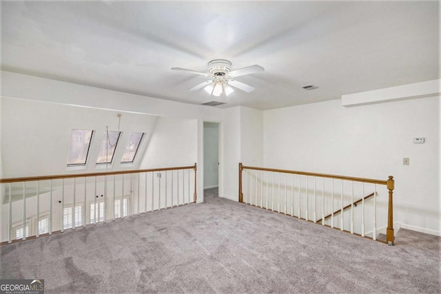 carpeted spare room featuring ceiling fan