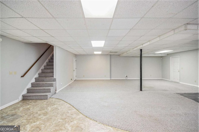 basement featuring carpet floors and a drop ceiling