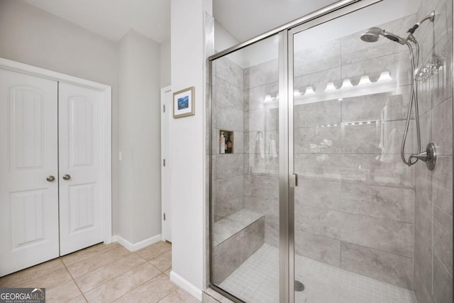 bathroom with a shower with shower door and tile patterned floors