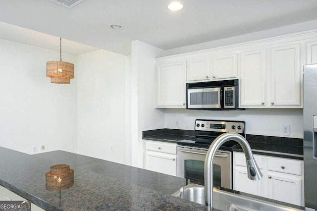 kitchen with appliances with stainless steel finishes, white cabinets, and sink