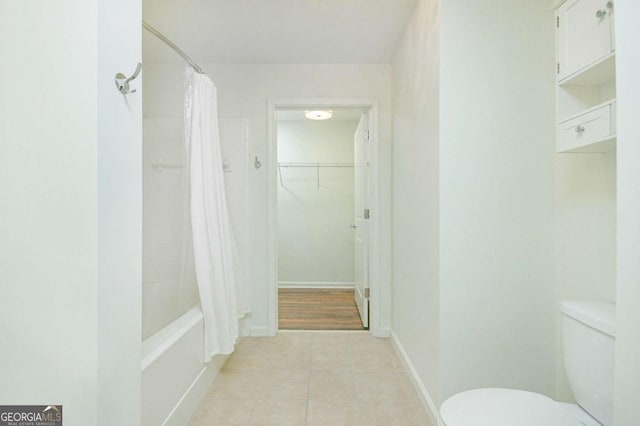 bathroom featuring toilet, tile patterned flooring, and shower / tub combo with curtain