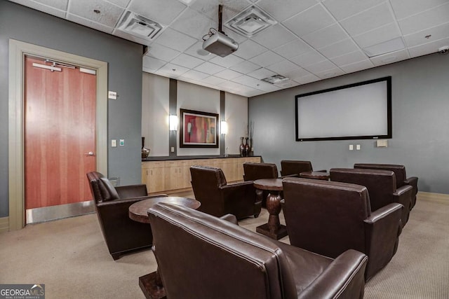 carpeted cinema with a paneled ceiling