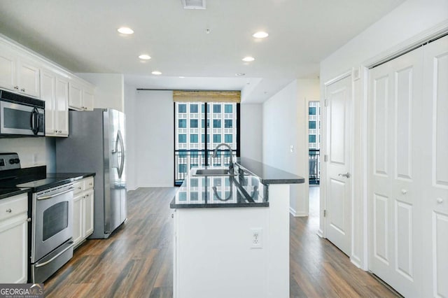 kitchen with a center island with sink, sink, white cabinetry, stainless steel appliances, and dark hardwood / wood-style flooring