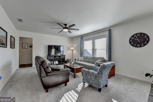 carpeted living room with ceiling fan