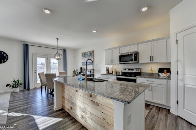 kitchen with stainless steel appliances, sink, a center island with sink, and white cabinets