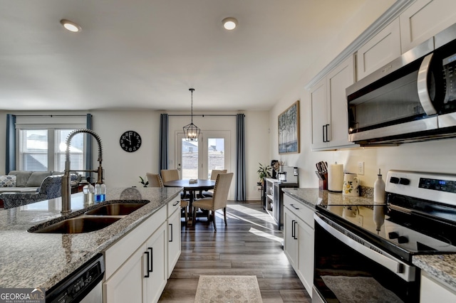 kitchen featuring stainless steel appliances, light stone countertops, sink, and white cabinets