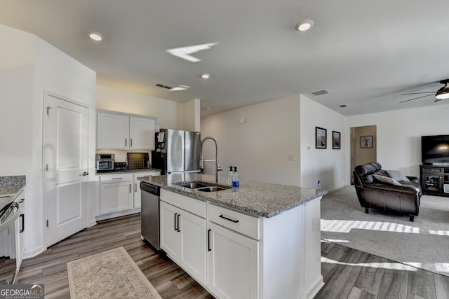 kitchen featuring an island with sink, appliances with stainless steel finishes, sink, and white cabinets