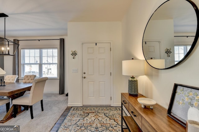 entrance foyer featuring carpet flooring and an inviting chandelier