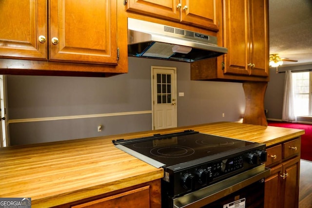 kitchen featuring electric stove, butcher block countertops, and ceiling fan