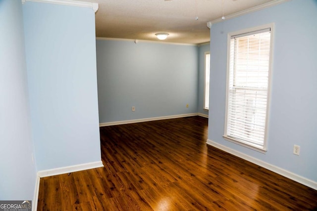 empty room with a textured ceiling, ornamental molding, and dark hardwood / wood-style floors