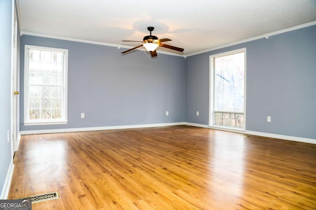 empty room featuring ceiling fan, light wood-type flooring, ornamental molding, and a textured ceiling