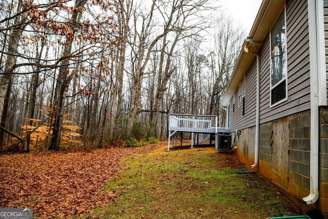 view of yard with a wooden deck and central AC unit