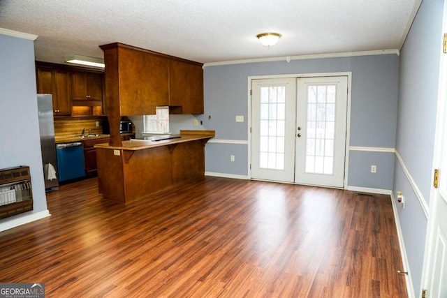 kitchen featuring crown molding, heating unit, a kitchen breakfast bar, stainless steel appliances, and french doors